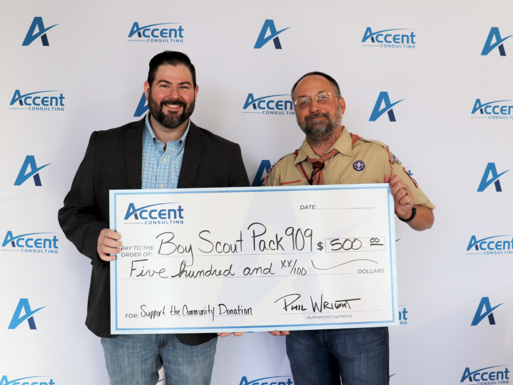 Accent CEO Phil holding a big cheque of 500 dollars showing support for the Boy Scouts.